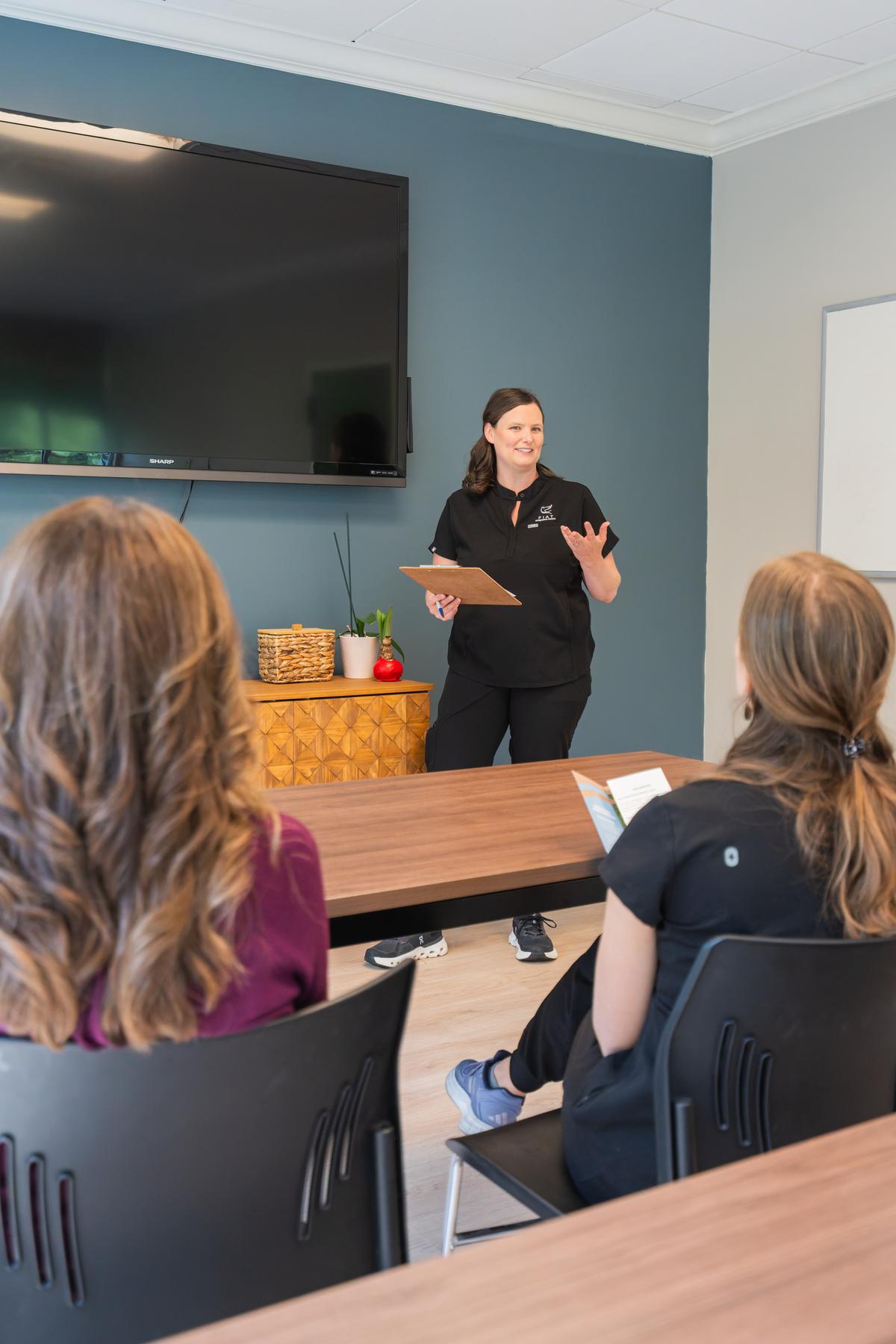 A Fiat provider leading a small class in a conference room